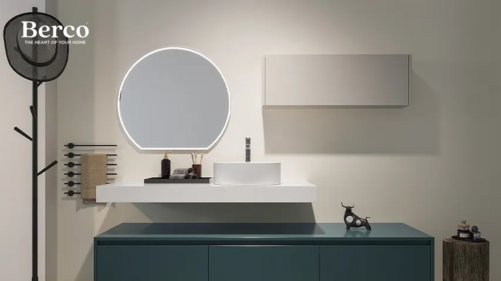 A slim stone basin ledge with a vessel bowl above a deep teal drawer console, set between a round lit mirror and a slim wall cabinet — Berco design reference.