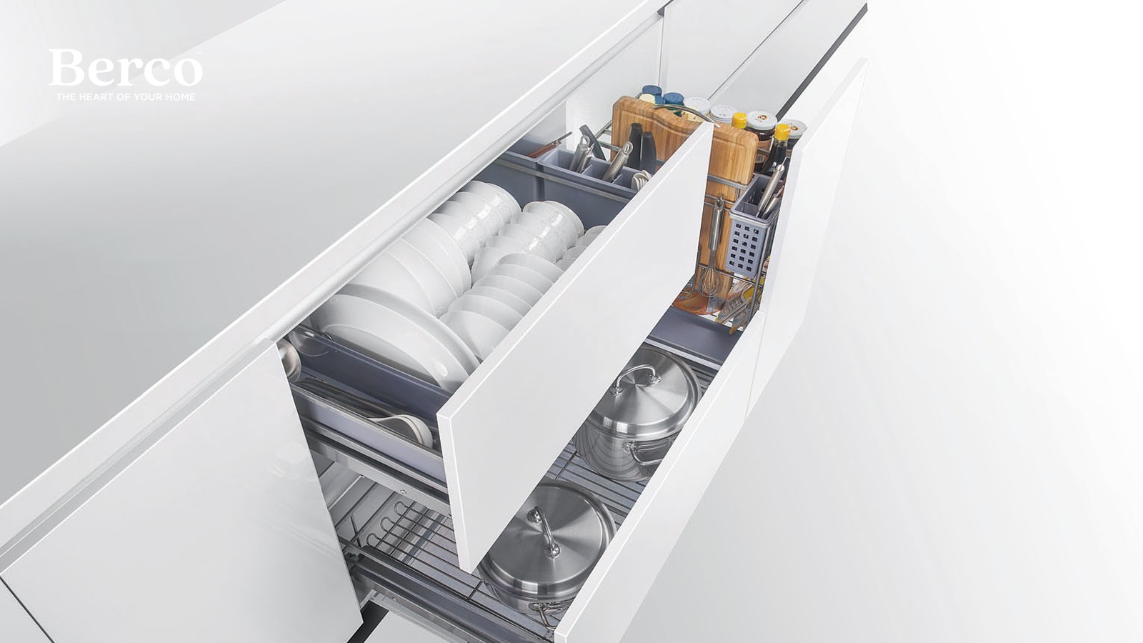A deep drawer stack holding plates upright in a rack with a divided cutlery tray above, and pots and lids on wire racks below — Berco design reference.