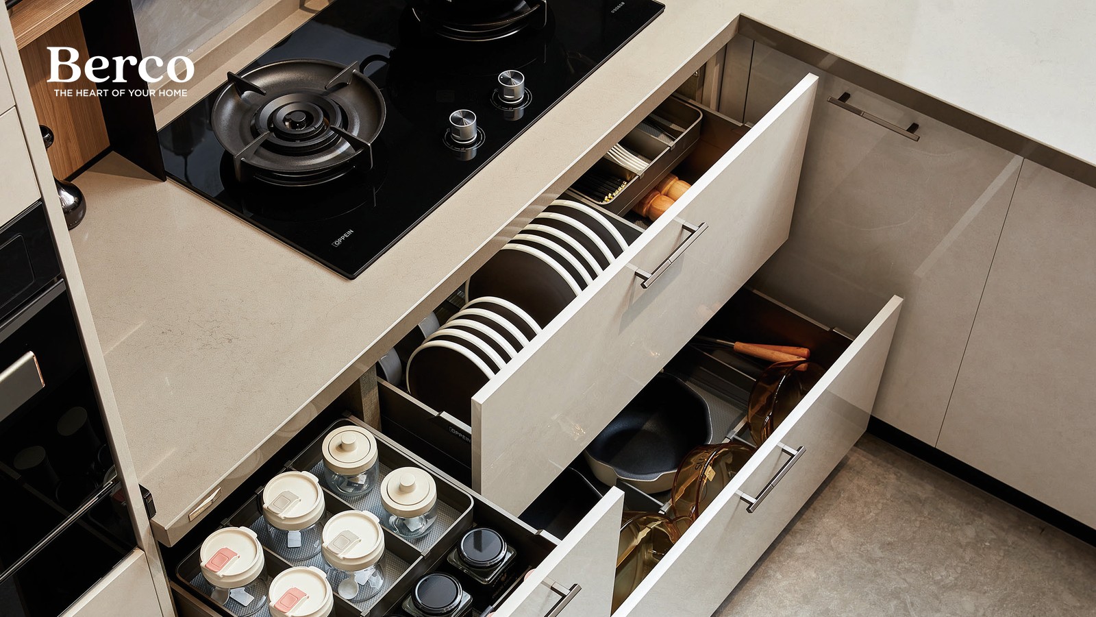 Two deep base drawers fitted with upright plate racks and cup holders beside a hob — Berco design reference